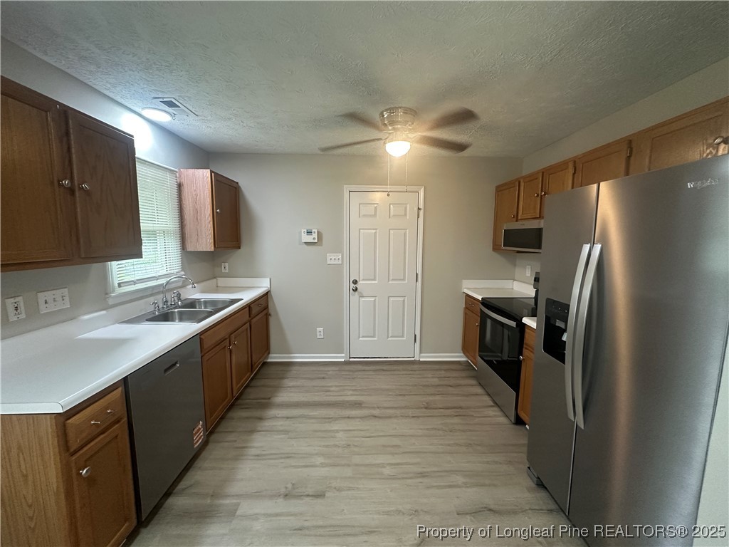 75 Tradewinds Drive Spring Lake, NC 28390 - Photo 6 of 26 a large kitchen with a large counter top a sink a refrigerator and cabinets