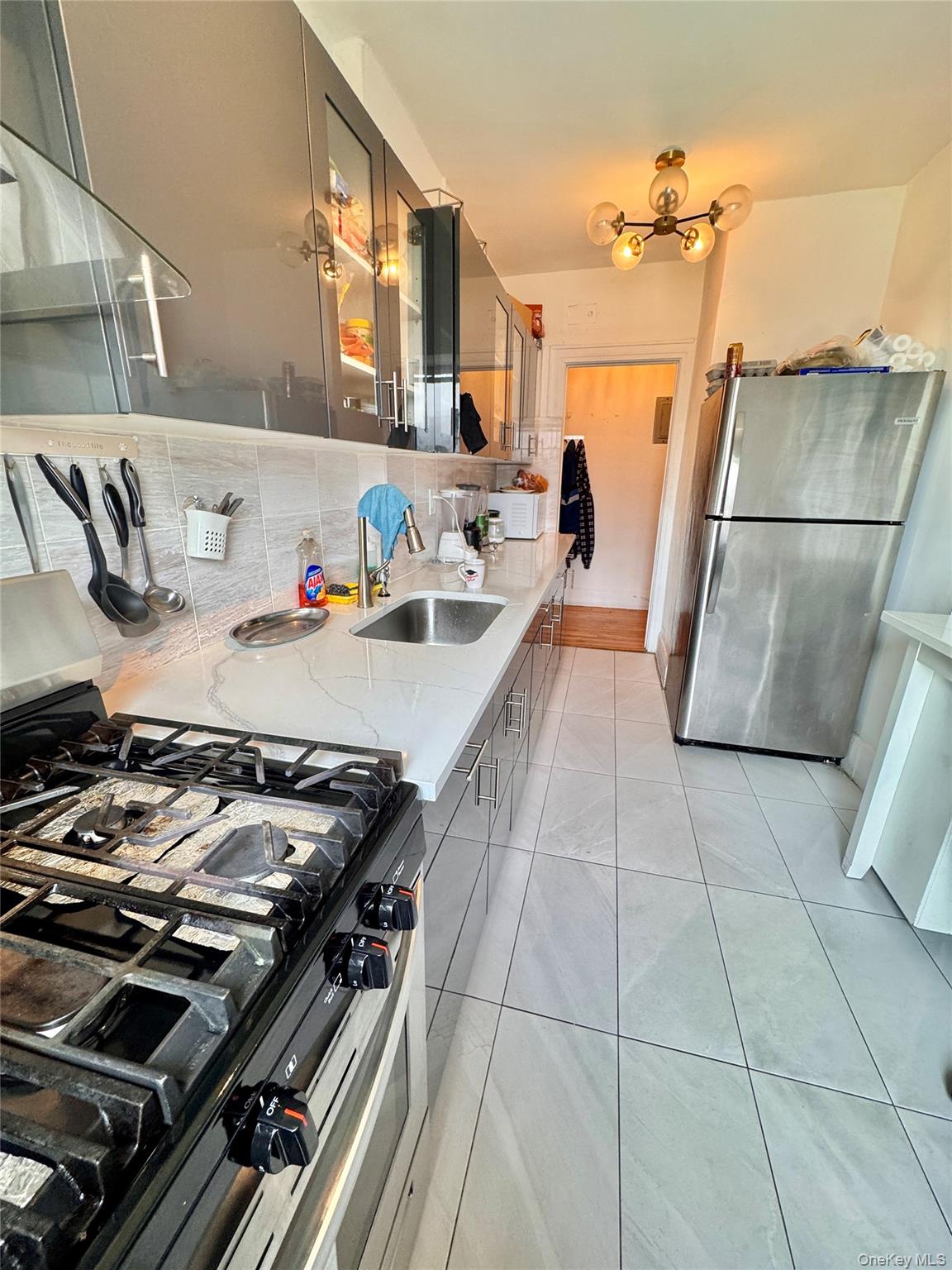 98-15 34th Avenue Queens, NY 11368 - Photo 11 of 41 a kitchen with a stove and a refrigerator
