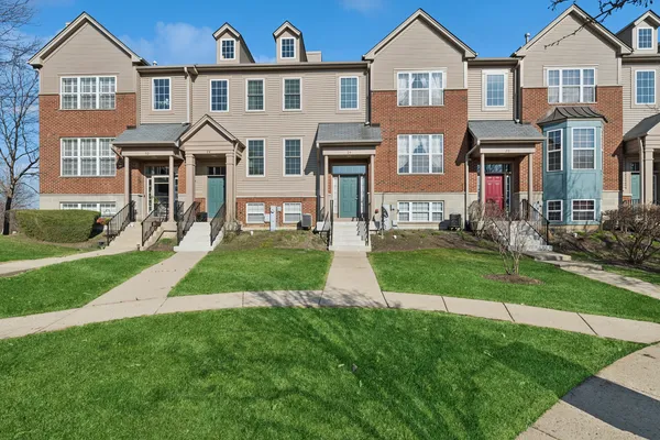 a front view of a residential houses with yard and green space