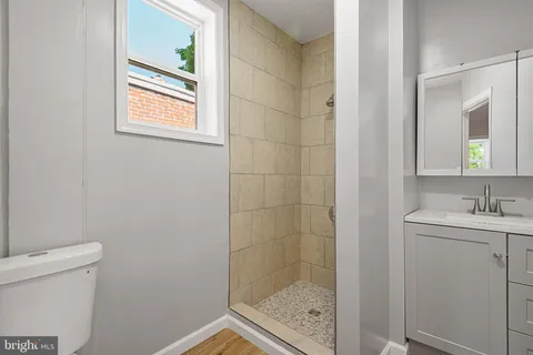 a bathroom with a granite countertop sink a toilet and a mirror