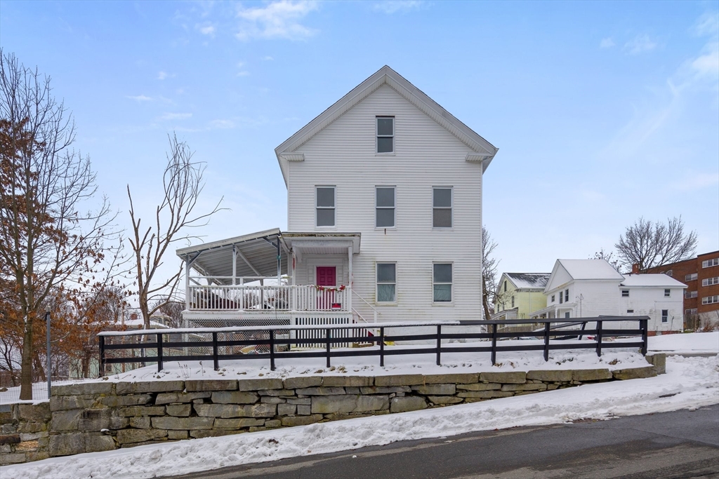a view of a white house with a yard and plants