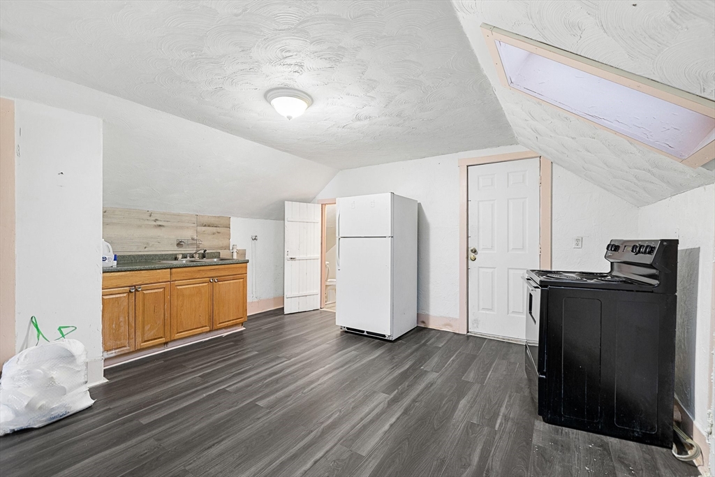 1 Ely Street Worcester, MA 01610 - Photo 18 of 25 a kitchen with a refrigerator and white cabinets