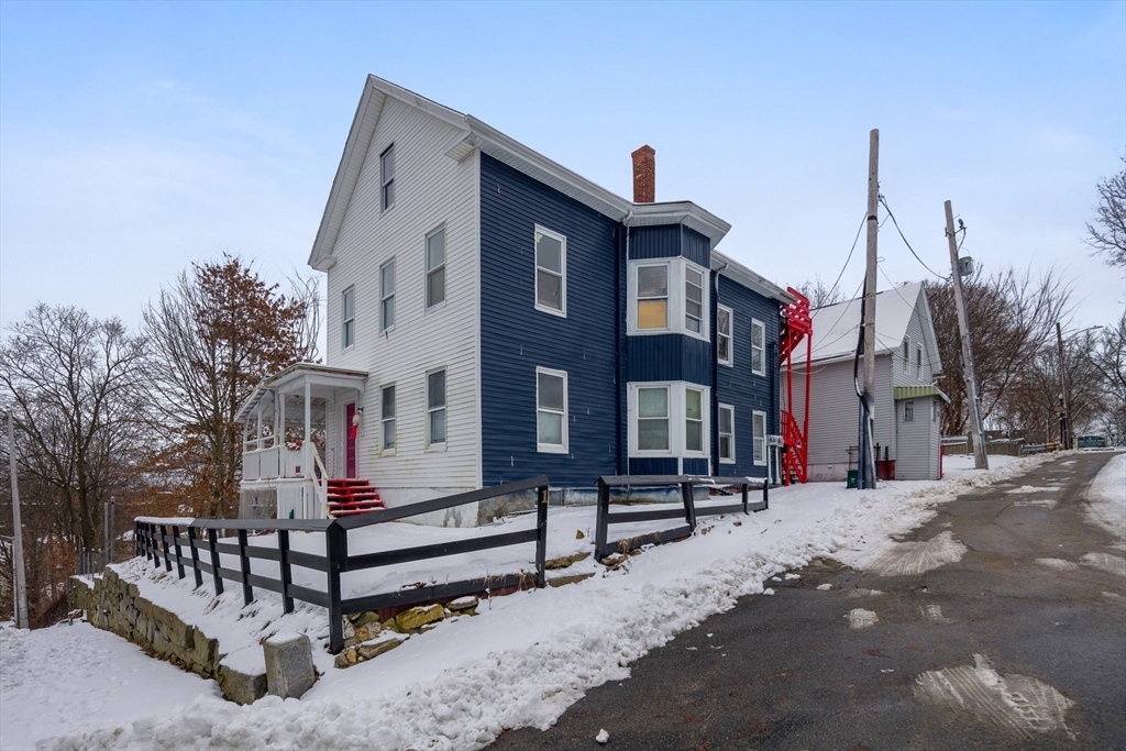 1 Ely Street Worcester, MA 01610 - Photo 2 of 25 a front view of a building with a yard covered with snow