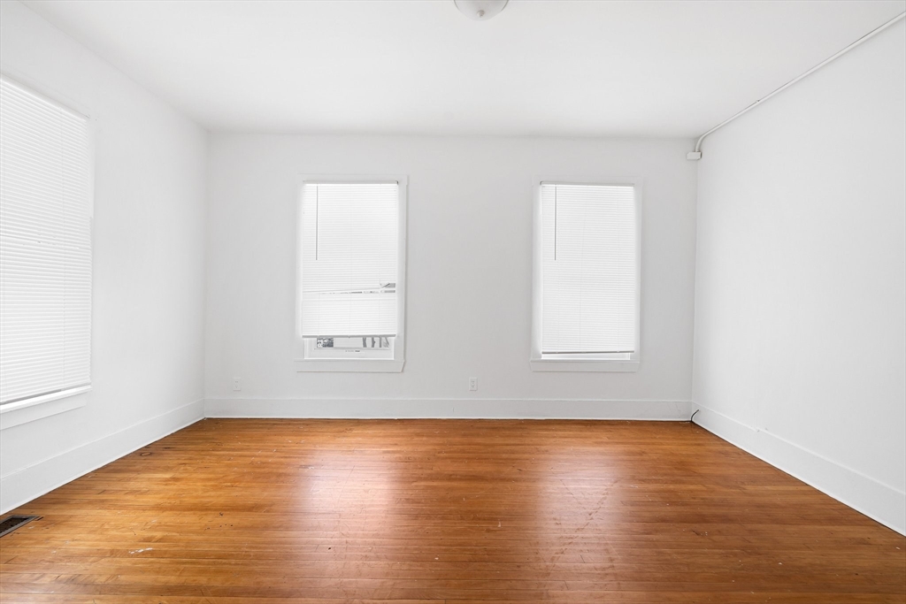 1 Ely Street Worcester, MA 01610 - Photo 5 of 25 an empty room with wooden floor and windows