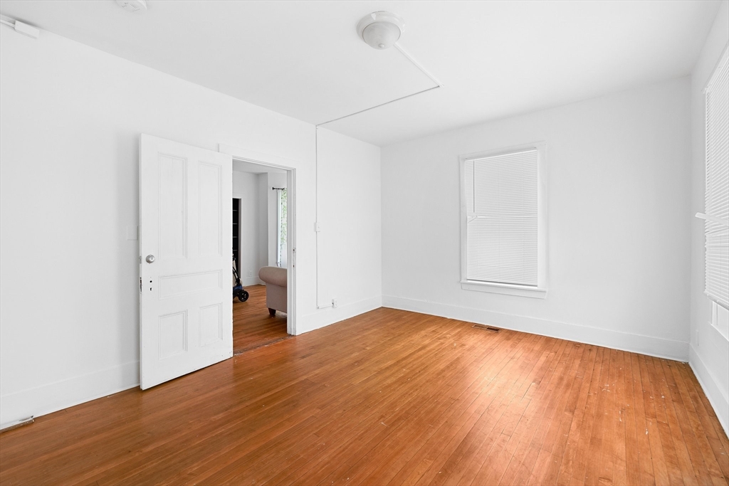 1 Ely Street Worcester, MA 01610 - Photo 6 of 25 an empty room with wooden floor and bathroom view