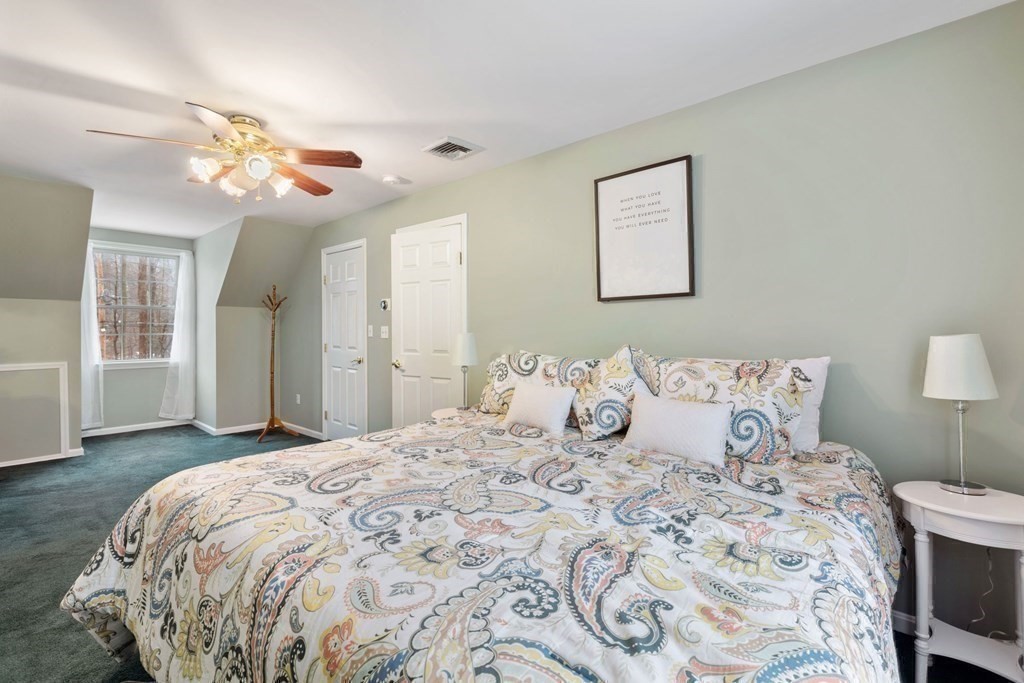 22 Oak Road Littleton, MA 01460 - Photo 18 of 42 a bedroom with a large bed and a chandelier