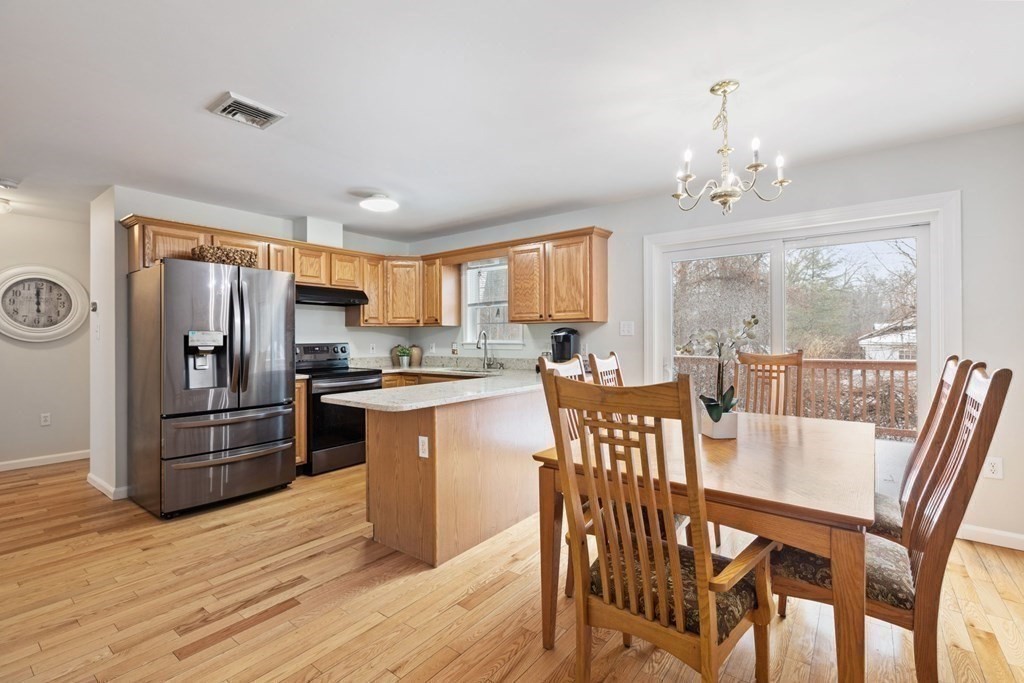 22 Oak Road Littleton, MA 01460 - Photo 6 of 42 a kitchen with stainless steel appliances granite countertop a dining table chairs refrigerator and a sink
