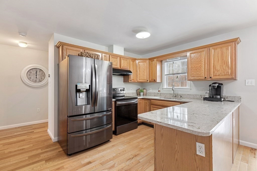 22 Oak Road Littleton, MA 01460 - Photo 9 of 42 a kitchen with granite countertop stainless steel appliances a refrigerator microwave and sink