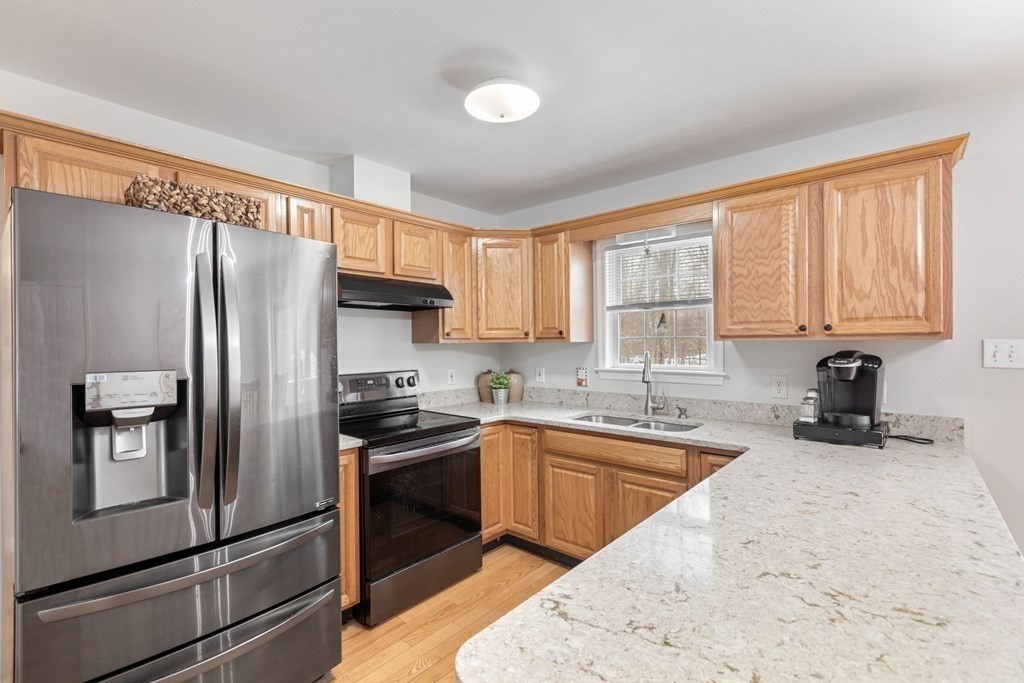22 Oak Road Littleton, MA 01460 - Photo 10 of 42 a kitchen with granite countertop stainless steel appliances a refrigerator sink and microwave