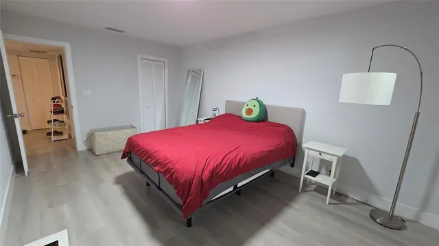 a bedroom with a bed a table and dresser