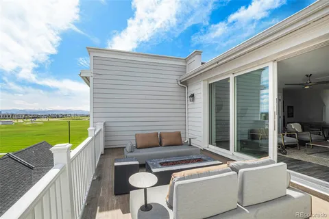 a view of a patio with couches chairs and a floor to ceiling window