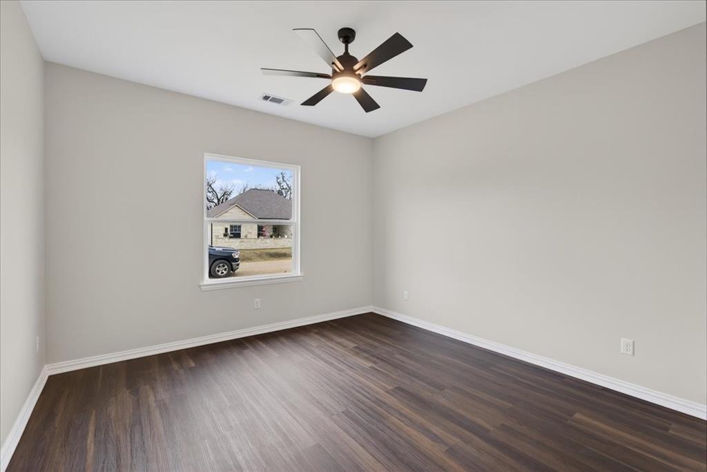117 East Bexar Street Mabank, TX 75147 - Photo 14 of 27 an empty room with wooden floor and windows