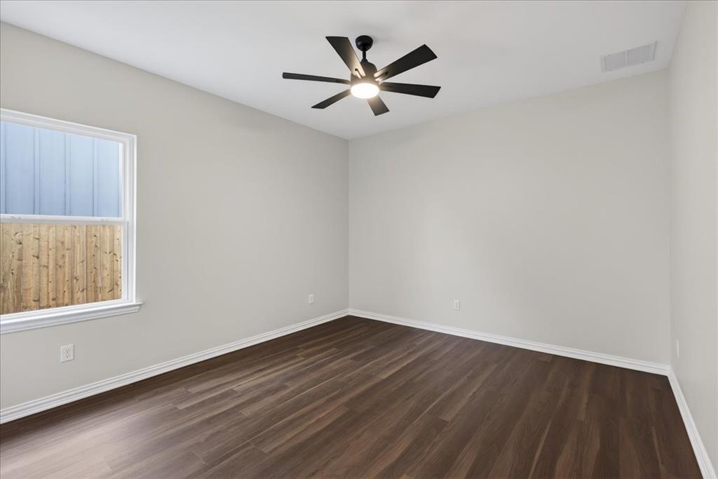117 East Bexar Street Mabank, TX 75147 - Photo 15 of 27 an empty room with wooden floor and windows