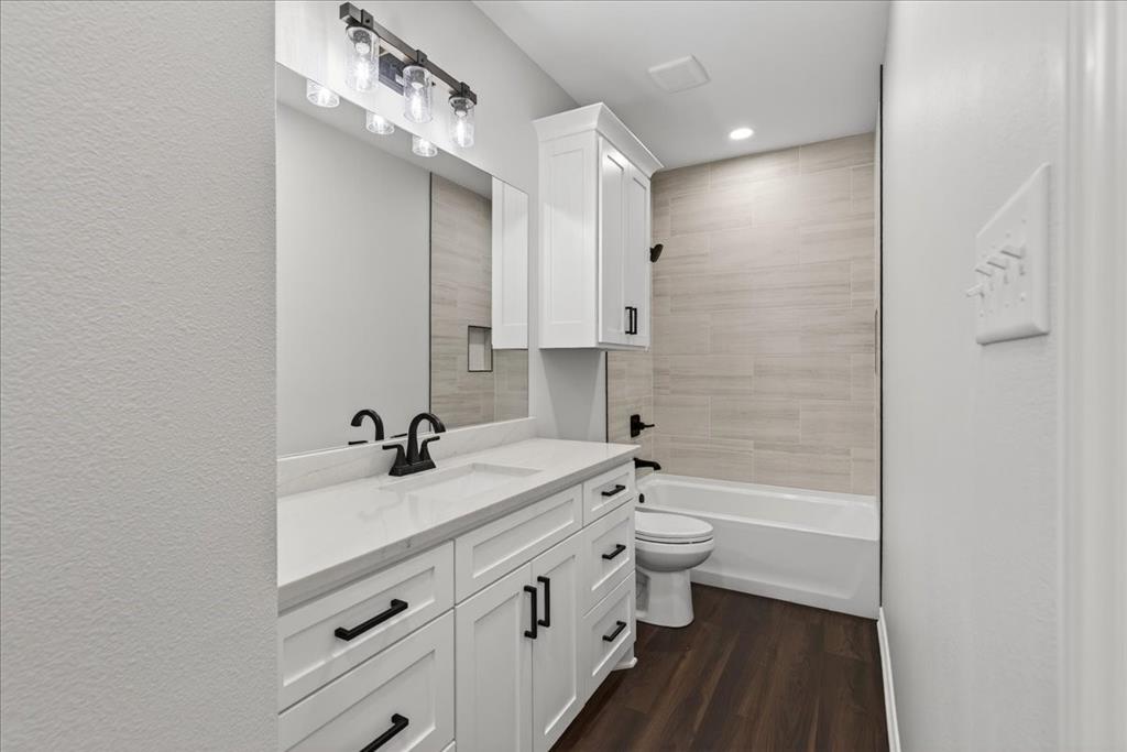 117 East Bexar Street Mabank, TX 75147 - Photo 16 of 27 a bathroom with a double vanity sink toilet mirror and bathtub