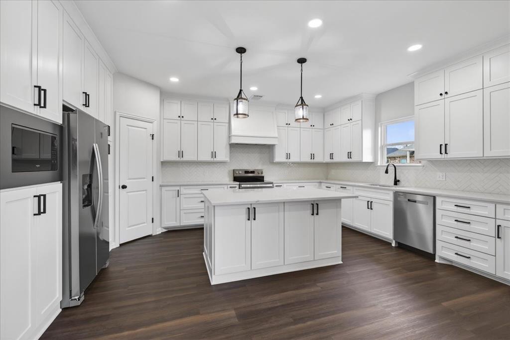 117 East Bexar Street Mabank, TX 75147 - Photo 5 of 27 a large kitchen with stainless steel appliances granite countertop a stove a sink a refrigerator and white cabinets with wooden floor