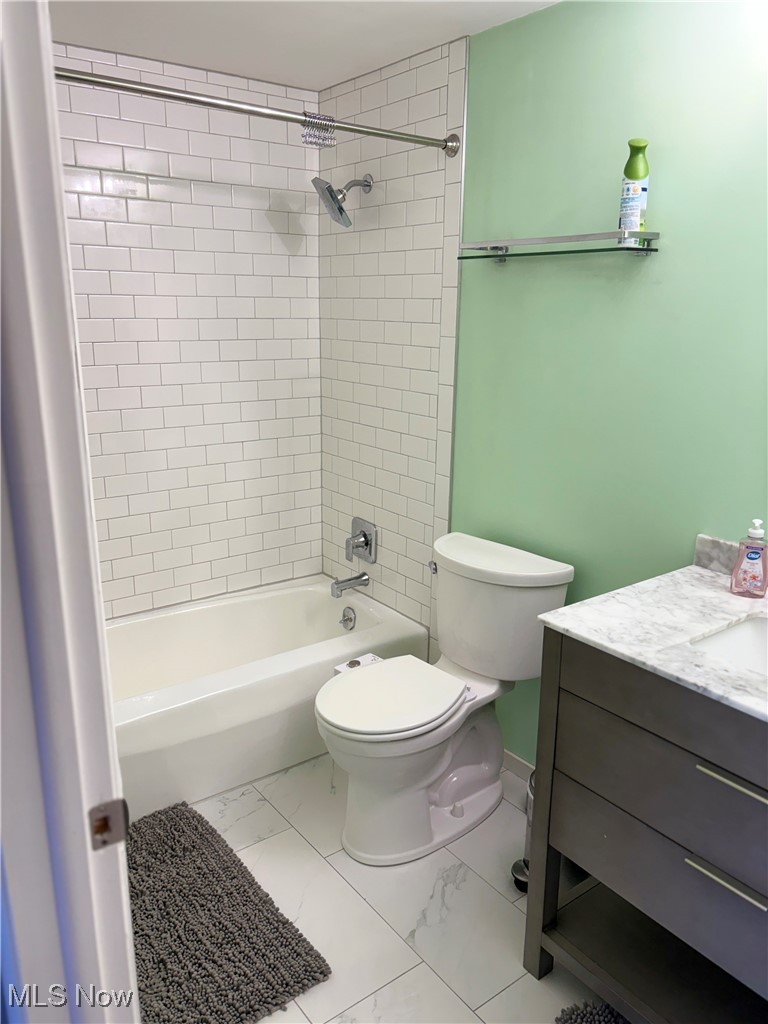 935 Canyon View Road, Unit 104 Northfield, OH 44067 - Photo 18 of 46 Bathroom with toilet, vanity, washtub / shower combination, marble finish floor, and baseboards