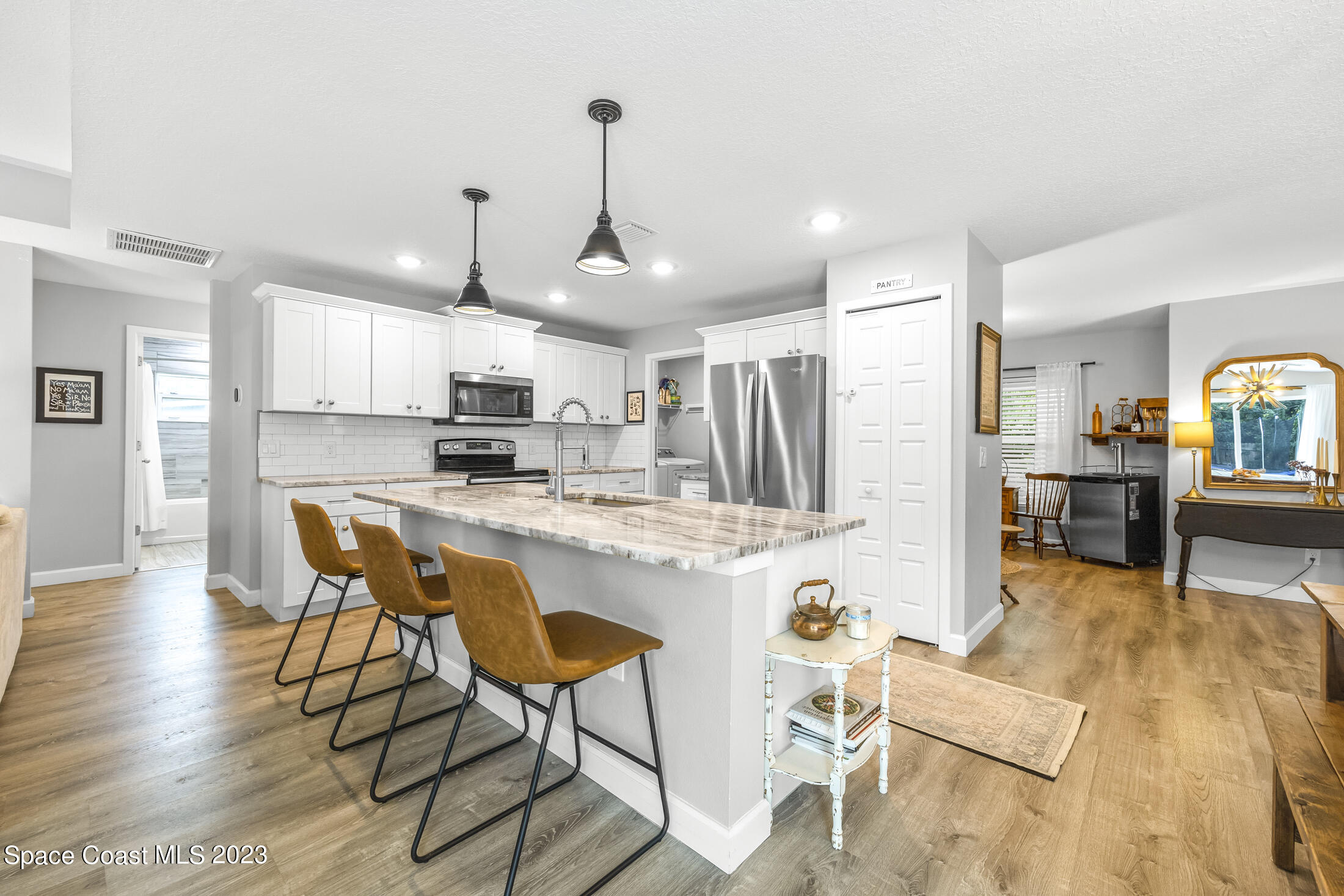 1003 Hayden Road Rockledge, FL 32955 - Photo 2 of 29 a kitchen with stainless steel appliances kitchen island granite countertop a table chairs and a refrigerator