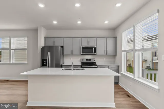 a kitchen with stainless steel appliances a refrigerator stove microwave and sink