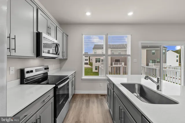 a kitchen that has a sink a stove and cabinets