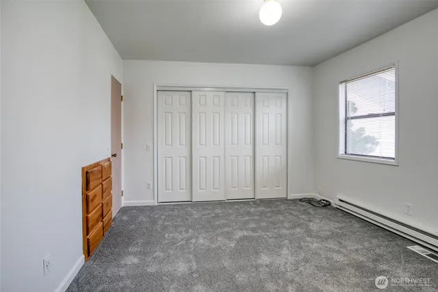 an empty room with windows and closet