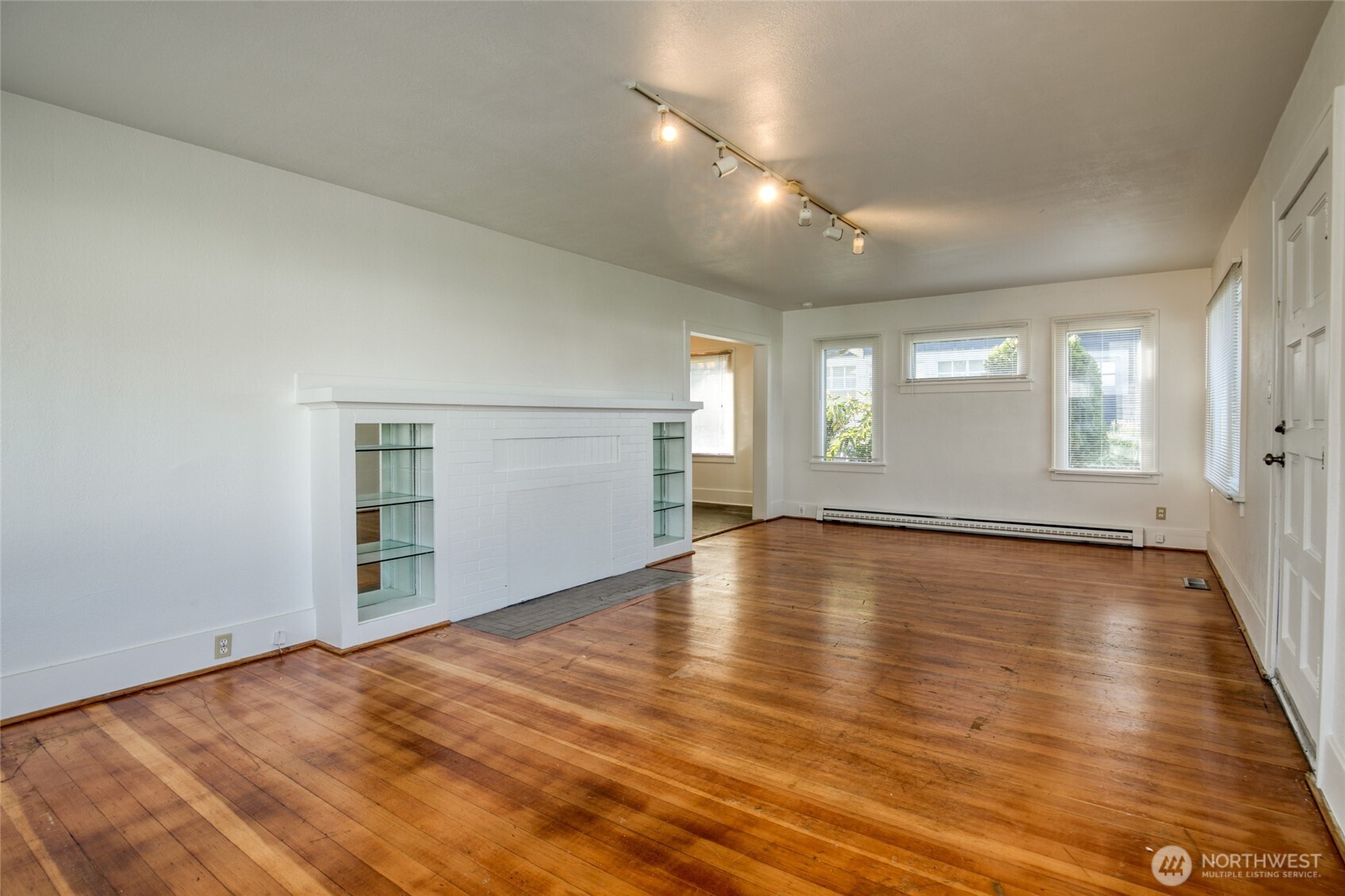 411 West 4th Street Aberdeen, WA 98520 - Photo 5 of 40 an empty room with wooden floor and windows