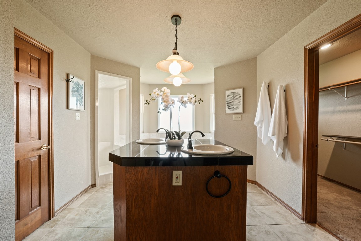 176 Logan Ranch Road Georgetown, TX 78628 - Photo 12 of 38 a bathroom with a granite countertop sink a refrigerator and a mirror
