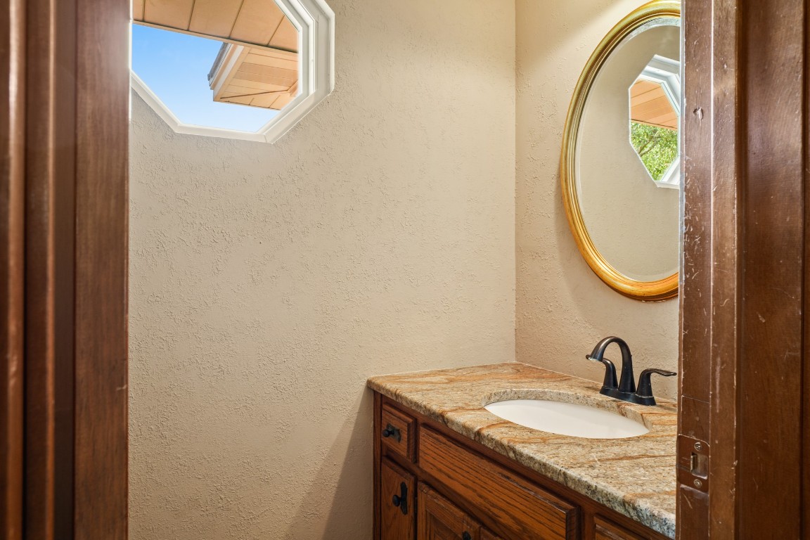 176 Logan Ranch Road Georgetown, TX 78628 - Photo 19 of 38 a bathroom with a granite countertop sink and a mirror