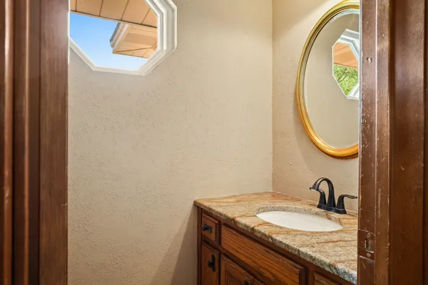a bathroom with a granite countertop sink and a mirror