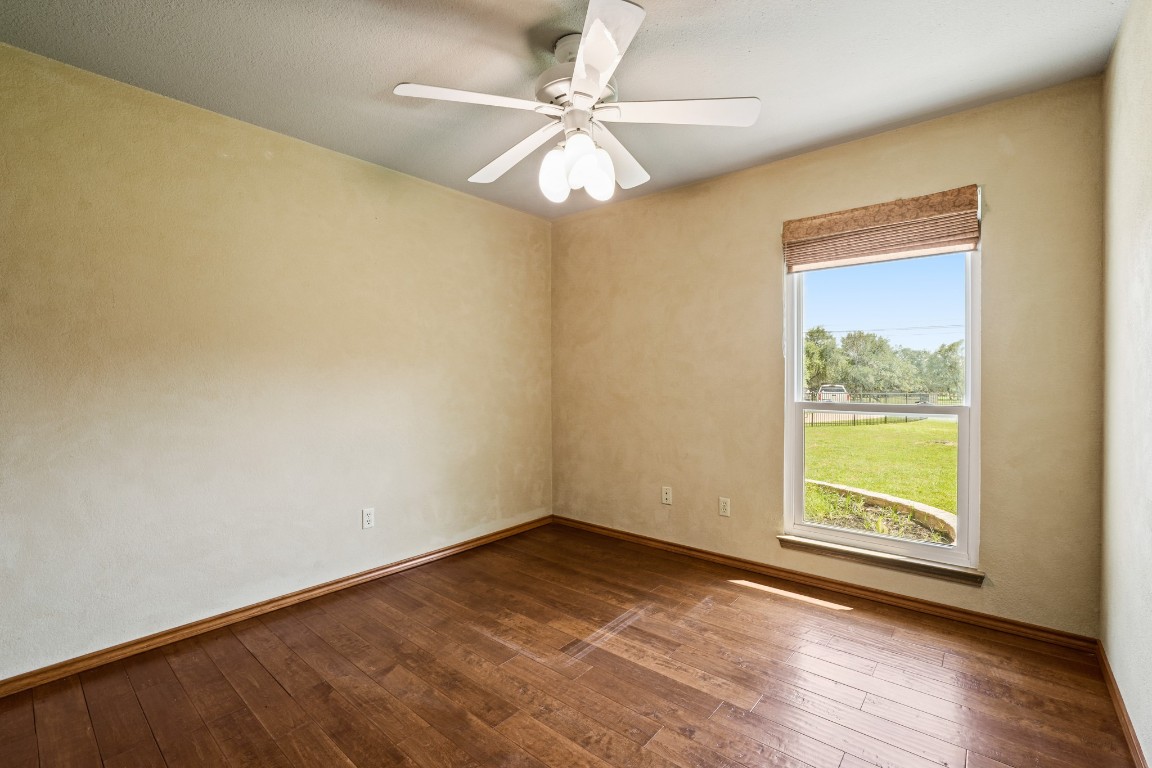 176 Logan Ranch Road Georgetown, TX 78628 - Photo 20 of 38 a view of an empty room with window and wooden floor