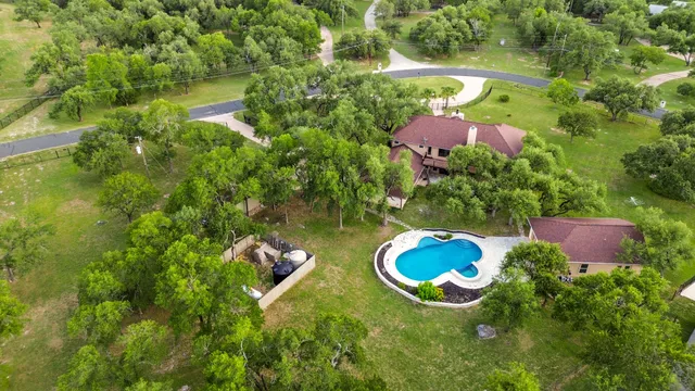 an aerial view of a house with a yard and lake view