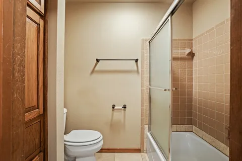 a bathroom with a granite countertop bathtub shower and toilet
