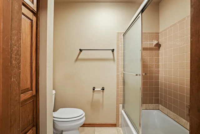 a bathroom with a granite countertop bathtub shower and toilet