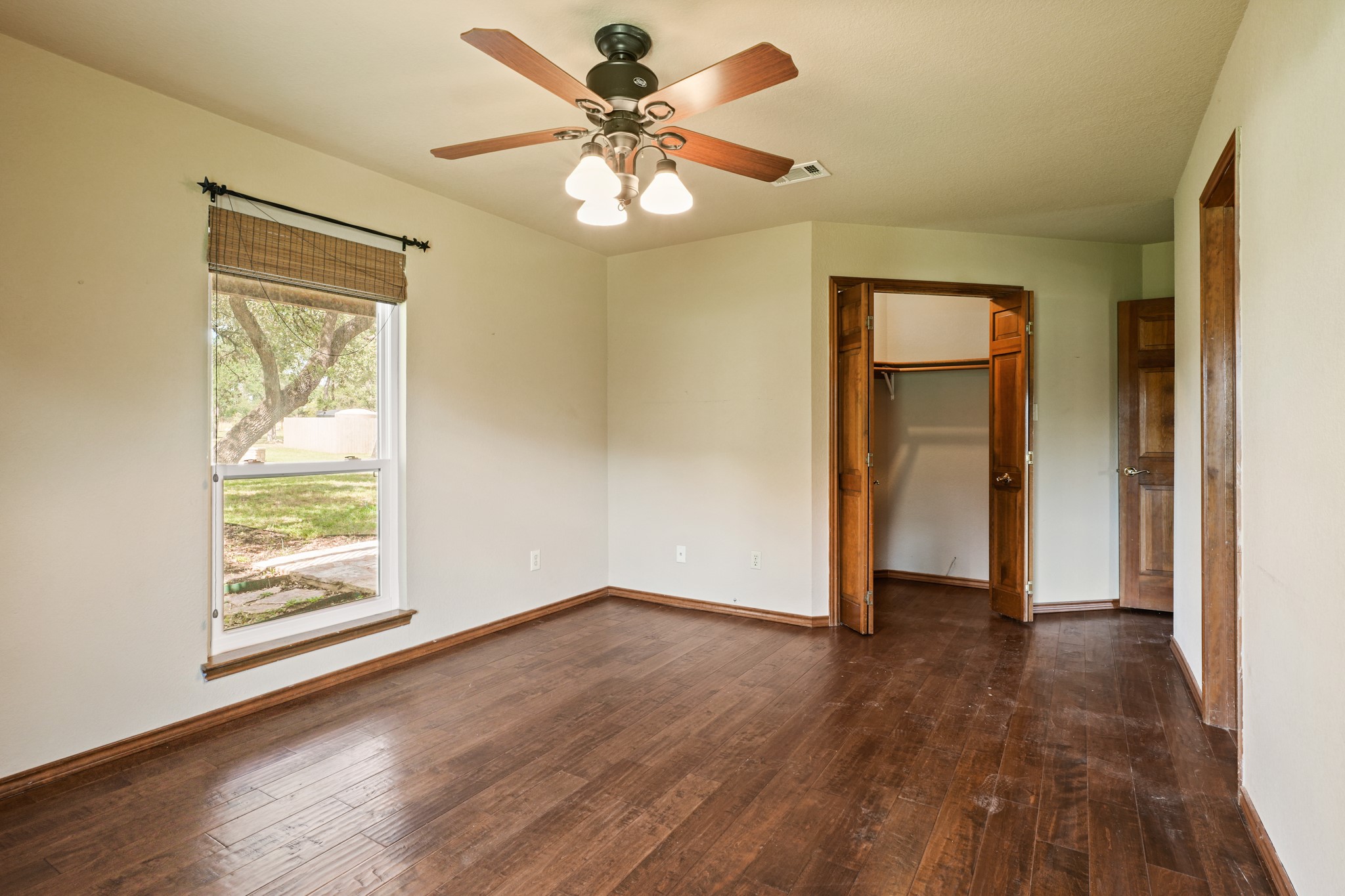 176 Logan Ranch Road Georgetown, TX 78628 - Photo 26 of 38 an empty room with wooden floor chandelier fan and windows