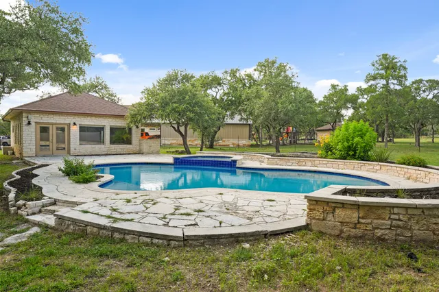a view of a house with pool and sitting area