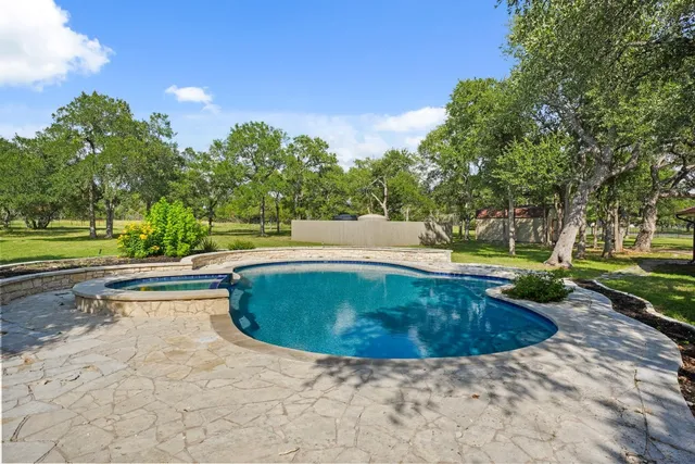 a view of a swimming pool with a yard and plants
