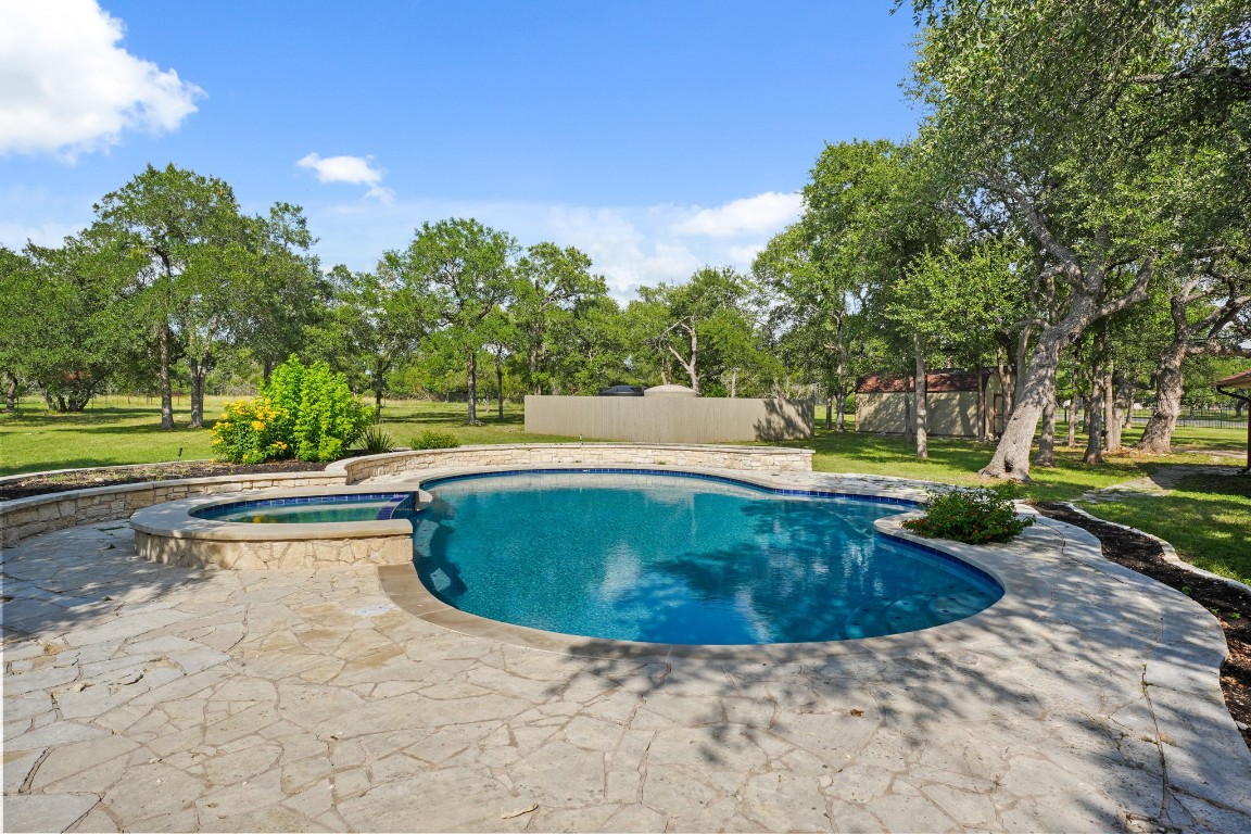 176 Logan Ranch Road Georgetown, TX 78628 - Photo 32 of 38 a view of a swimming pool with a yard and plants