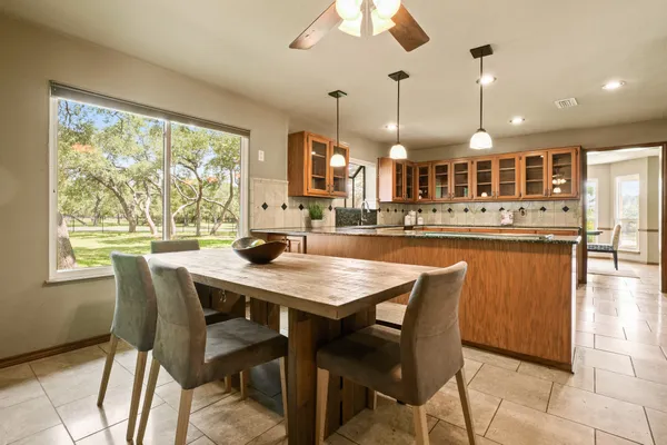 a dining table with chairs and kitchen view