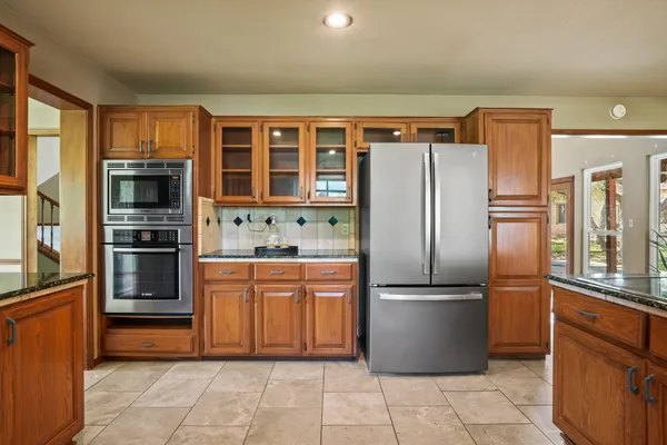 a kitchen with granite countertop a refrigerator and a sink