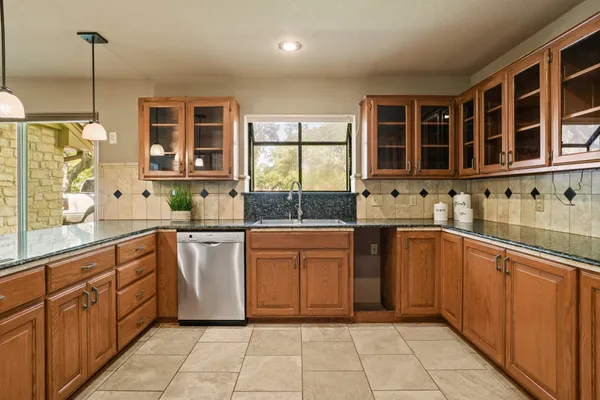 a kitchen with stainless steel appliances granite countertop a refrigerator and a sink
