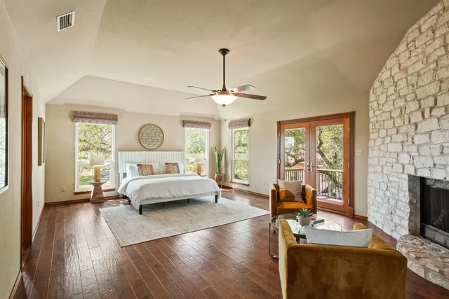 a bedroom with furniture large window and fireplace