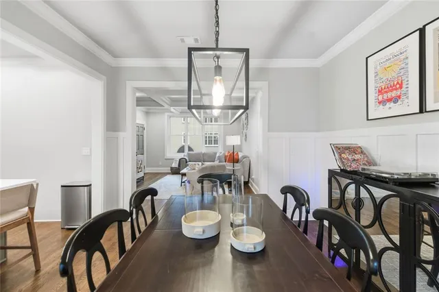 a view of a dining room with furniture a chandelier and wooden floor