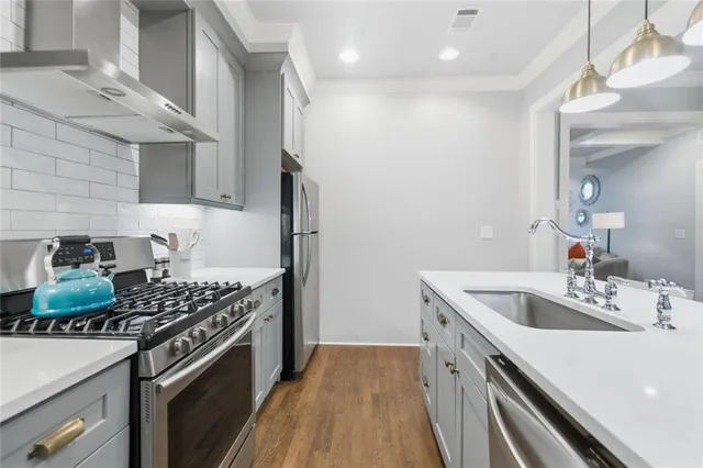 a kitchen with stainless steel appliances granite countertop a sink stove and refrigerator