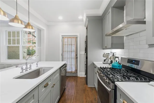 a kitchen with stainless steel appliances granite countertop a sink stove and cabinets