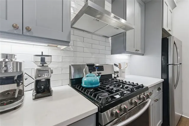 a kitchen with stainless steel appliances granite countertop a stove and a refrigerator