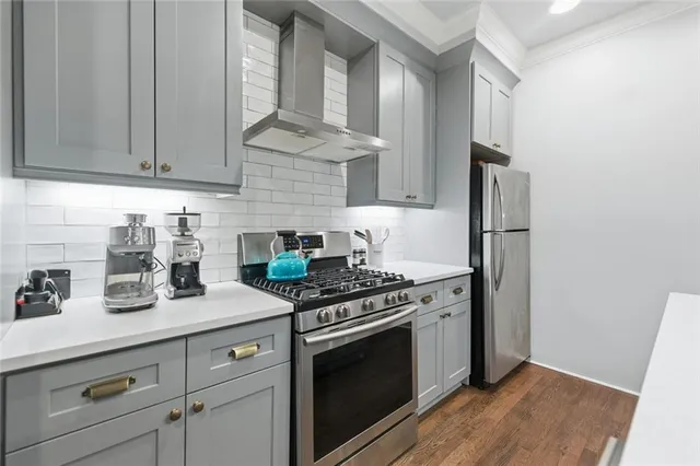 a kitchen with stainless steel appliances granite countertop a sink a stove a refrigerator and cabinets