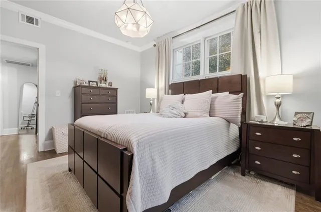 a bedroom with a bed and a chandelier next to a window