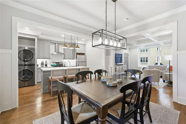 a view of a dining room and livingroom with furniture wooden floor a chandelier