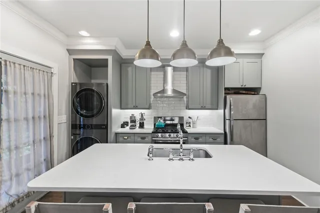 a kitchen with a sink a refrigerator and chairs