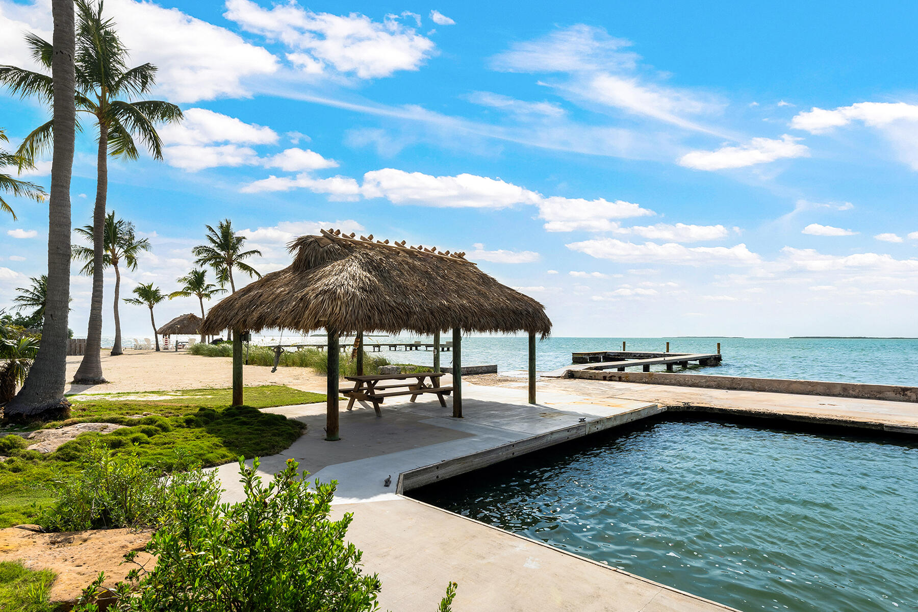36 Sunset Road Key Largo, FL 33037 - Photo 13 of 25 a view of a swimming pool with a table and chairs under an umbrella