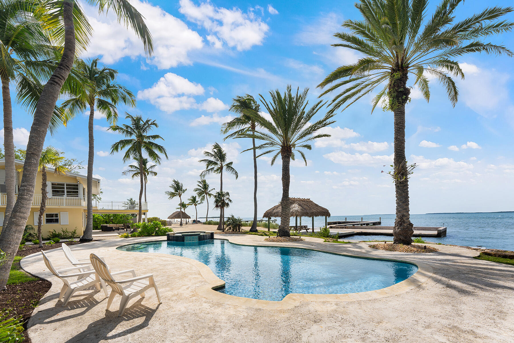 36 Sunset Road Key Largo, FL 33037 - Photo 7 of 25 a view of a swimming pool with a lawn chairs and palm tree